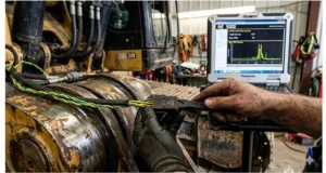 Technician performing systematic wiggle test on a J1939 Deutsch connector to locate an intermittent harness open in heavy equipment CAN bus