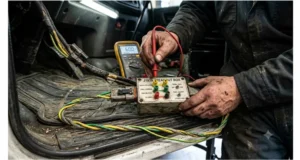 J1939 breakout kit in use with multimeter probes on CAN_H and CAN_L banana jacks to diagnose an intermittent heavy-duty truck communication fault